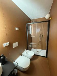 a bathroom with a toilet and a glass shower at Ortigia_corte d'avolio in Siracusa