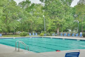 een groot zwembad met blauwe stoelen en bomen bij WFH-Friendly Summerville Home with Community Pool in Summerville