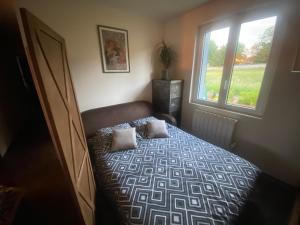 a bedroom with a bed and a window at La Maison Sous Charmois in Verdun