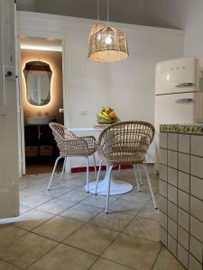 a kitchen with a table and chairs and a refrigerator at Ortigia_corte d'avolio in Siracusa