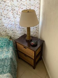 a lamp on a night stand next to a bed at Seawinds Apartments in Christ Church