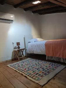 sypialnia z łóżkiem i dywanem na podłodze w obiekcie Poial da Bia w mieście Mértola