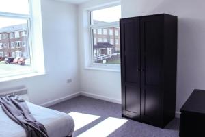 una camera da letto con un armadio nero accanto a una finestra di Comfy 1BR Apartment with Great Amenities a Heywood