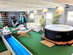 a room with a large bath tub and a slide at Wellness zur Alleinnutzung mit Ferienwohnung und Fitnessbereich - fitSPA in Sulz am Neckar