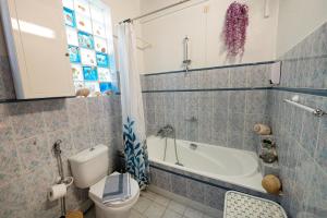 uma casa de banho com um WC e uma banheira em Villa Sofia Sea View em Poros