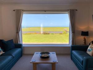 a living room with a couch and a large window at Ocean View apartment, beautiful sea views in Kent