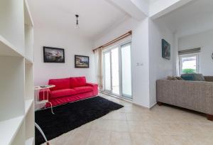 a living room with a red couch and a window at Sea View Duplex Private Villa in Bodrum Gundogan in Gundogan