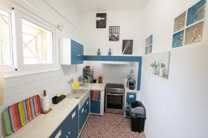 a small kitchen with blue cabinets and a sink at Villa Sofia Sea View in Poros