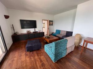 een woonkamer met een bank en een tv bij Villa ALDIANA in Cap Skirring