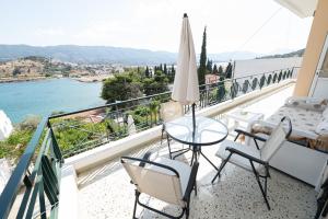 a balcony with a table and chairs and a view of the water at Villa Sofia Sea View in Poros