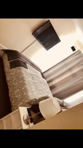 a bedroom with a bed and a tv on the ceiling at Ac lounge36 (B) in Rochford