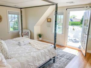1 dormitorio con 1 cama grande en una habitación con ventanas en Spacious Game Room Close to Nauset Beach, en Orleans