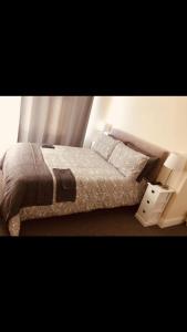 a bedroom with a bed and a night stand at Ac lounge36 (B) in Rochford
