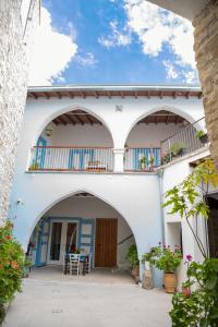 a building with an archway and a patio with a table at 7Kamares in Pano Lefkara