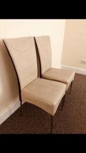 a pair of white chairs sitting in a room at Ac lounge36 (B) in Rochford