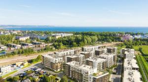 WOW FLOU Przystań Letnica Apartamenty 700m plaża في غدانسك: اطلالة جوية على مدينة بها مباني والمحيط
