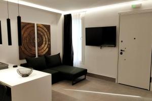 a living room with a couch and a flat screen tv at Ρομαντική απόδραση με Χαμάμ in Athens