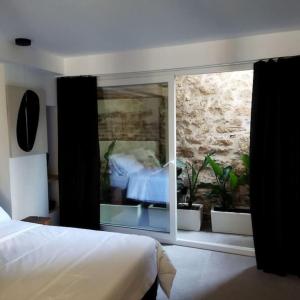 a bedroom with a view of a bed and a window at Χώρος με επιλεκτική λιτότητα και χαμάμ in Athens