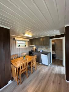 貝圖斯托的住宿－Liten og koselig hytte，厨房配有木桌和木椅
