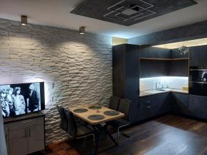 ein Esszimmer mit einem Tisch und einer Steinmauer in der Unterkunft Apartment Antea in Split