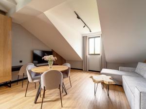 uma sala de estar com uma mesa e cadeiras e um sofá em Stek Apartments em Skawina