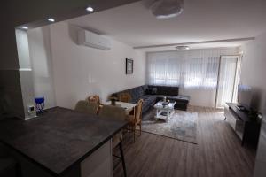 a living room with a couch and a table and a kitchen at Apartman Rossun in Bihać