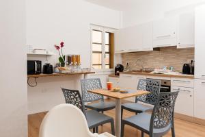 a kitchen with a table and chairs in a kitchen at La Casa di Ambra in Porto Torres