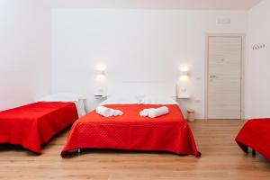 1 dormitorio con 2 camas con sábanas rojas en La Casa di Ambra, en Porto Torres