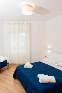 Un dormitorio con una cama azul con toallas. en La Casa di Ambra, en Porto Torres