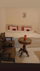 a bedroom with a bed and a table and a bed at Falcon pyramids inn in Cairo