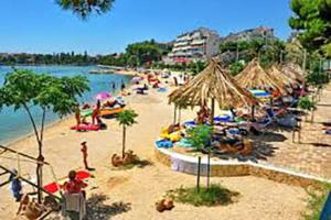 ein Strand mit vielen Menschen und Sonnenschirmen und dem Wasser in der Unterkunft Apartment Antea in Split