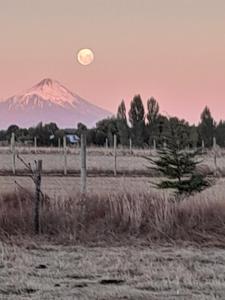 una montaña en la distancia con una luna en el cielo en Rio Maullin Lodge, en Puerto Varas