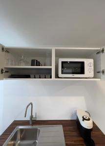 a kitchen with a sink and a microwave at L'Etape, logement climatisé ! in Beire-le-Châtel