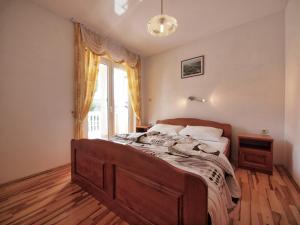 a bedroom with a bed with a large window at Apartments Vladimir in Vodice