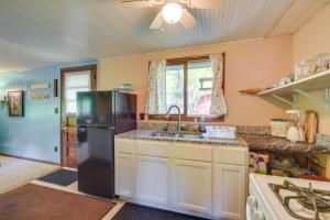 eine Küche mit einem schwarzen Kühlschrank und einer Spüle in der Unterkunft Riverfront Nature Getaway Near Downtown Pine City! in Pine City