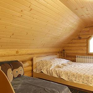 1 dormitorio con 2 camas en una cabaña de madera en У Медовому Раю, en Rostoka