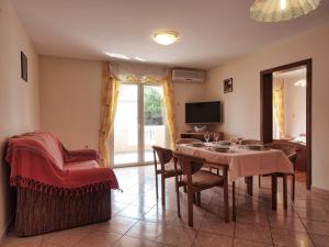 a living room with a table and chairs and a television at Apartments Vladimir in Vodice