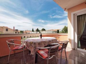 a table with chairs and a bottle of wine on a balcony at Apartments Vladimir in Vodice