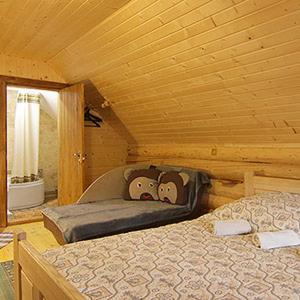 1 dormitorio con 1 cama en una cabaña de madera en У Медовому Раю en Rostoka