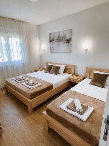 2 łóżka w pokoju hotelowym z ręcznikami w obiekcie Apartmani Živanović Ulcinj w Ulcinju