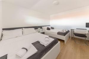 a white bedroom with a bed and a desk at Apartments ERA Ankaran in Ankaran