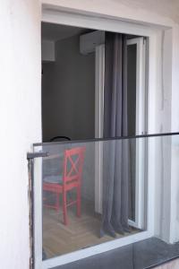een rode stoel in een kamer met een raam bij HostGost Selected Suites – Parliament in Belgrado