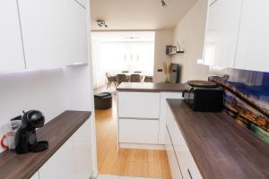 a kitchen with white cabinets and a counter top at Ted's Luxury Place with jacuzzi in Šibenik