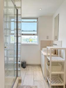 a bathroom with a glass shower and a sink at The London Loftscape in London