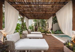 eine Veranda mit weißen Möbeln und einer Holzdecke in der Unterkunft Hotel Sutuk in Valladolid + 39 Fotos