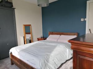 - une chambre avec un lit et un mur bleu dans l'établissement Castle Cottage, à Kendal
