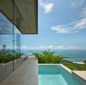 a pool in a house with a view of the ocean at ACHIOTÉ Architectural Gem - Adults Only in Uvita