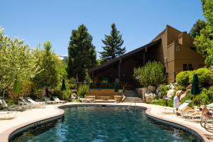 a pool at a resort with people sitting in chairs around it at Seasons Four 172 Two bedroom plus loft in Snowmass Village