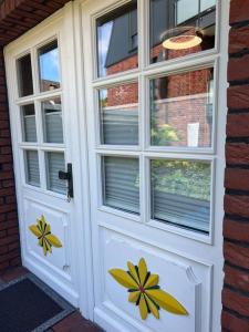 białe drzwi z namalowanymi kwiatami w obiekcie Ganze Haus für sich 6 Schlafplätze w mieście Buxtehude