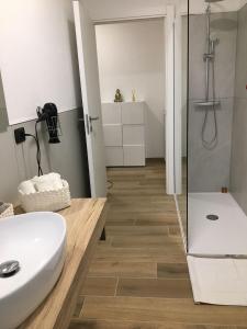 een badkamer met een witte wastafel en een douche bij Appartamento BELVEDERE in Castiglione Olona